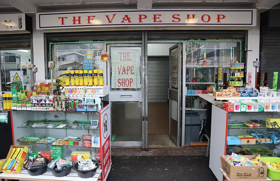 The Vape Shop front with an outside display of various coloured bottles and vaping equipment