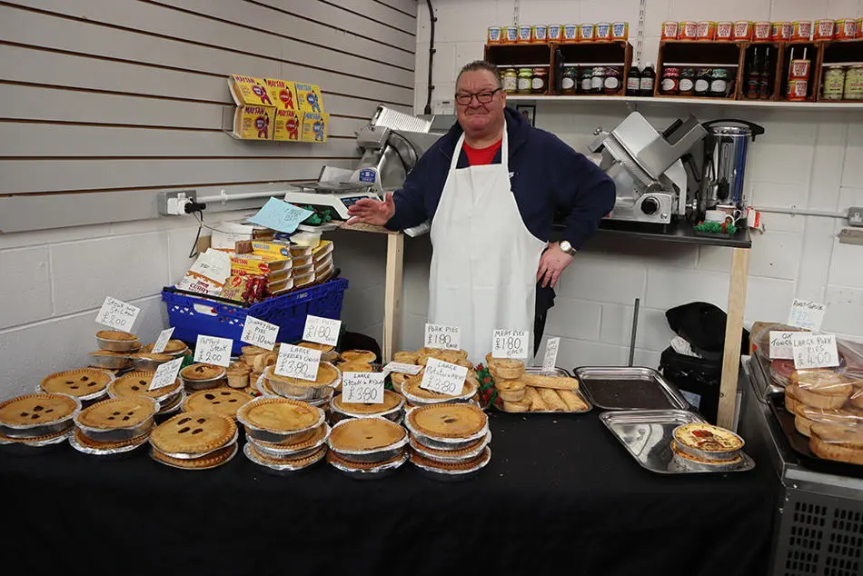 A person standing in front of a table full of pies