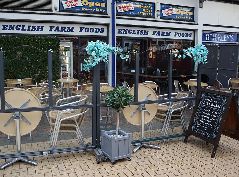 Shop front of English Farm Foods with tables and chairs outside