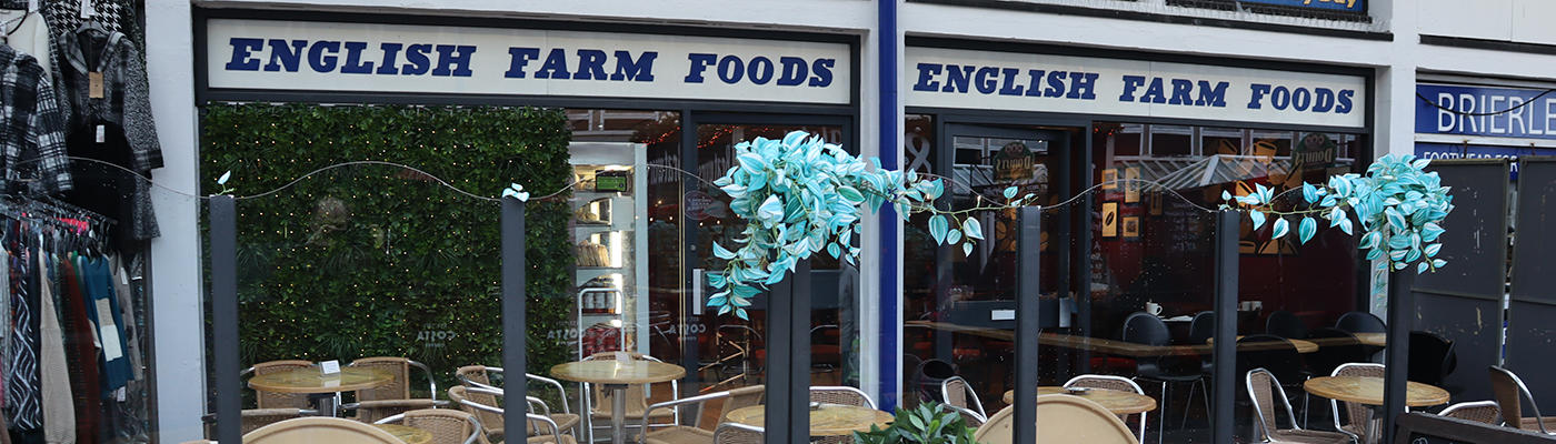 Shop front of English Farm Foods with tables and chairs outside