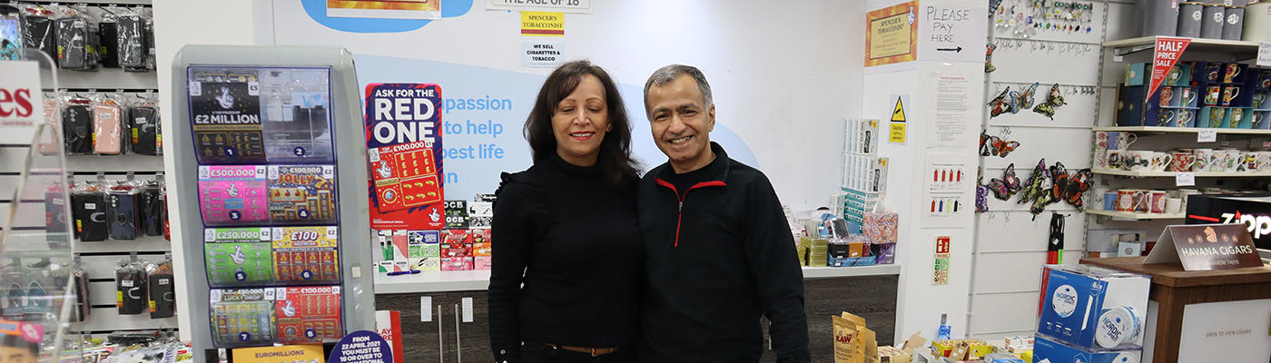 Two people standing behind a shop counter