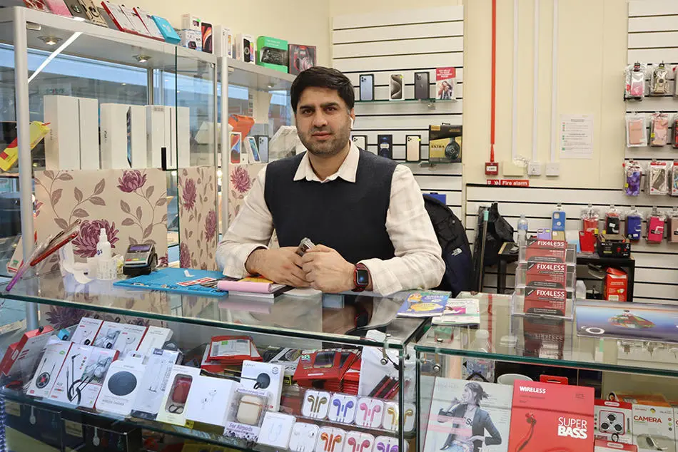 A person standing behind a display case full of computer items