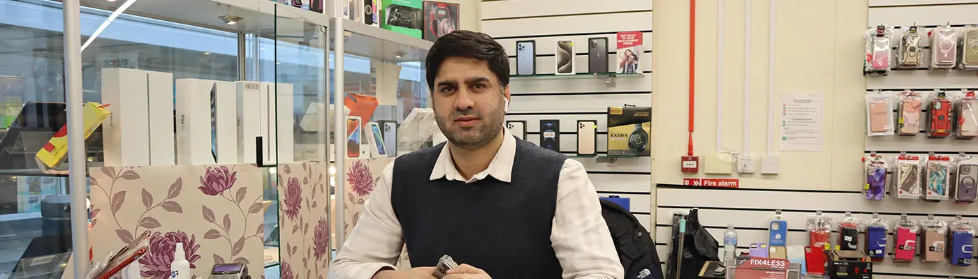 A person standing behind a display case full of computer items