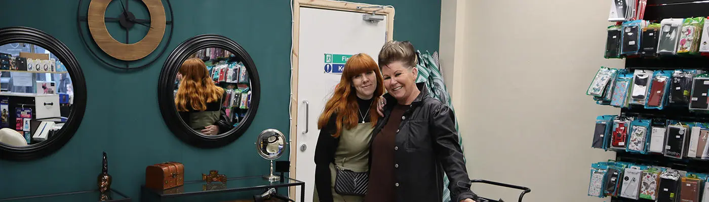 Two people standing in front of a barber's chair