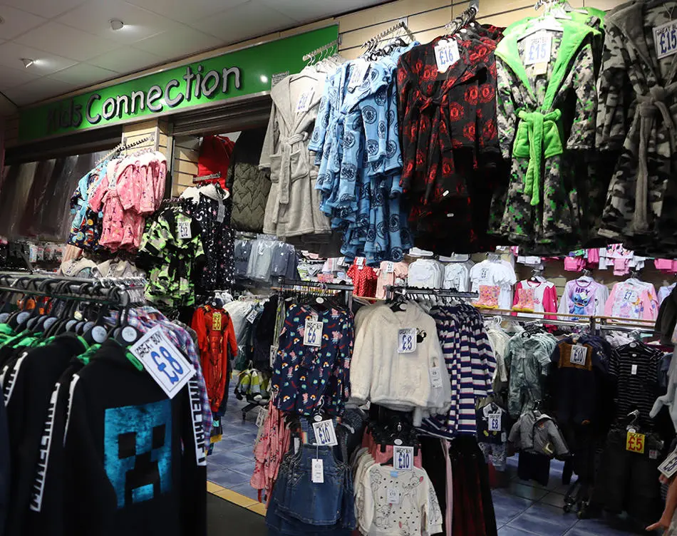 Shop front with rails of children's clothing and dressing gowns
