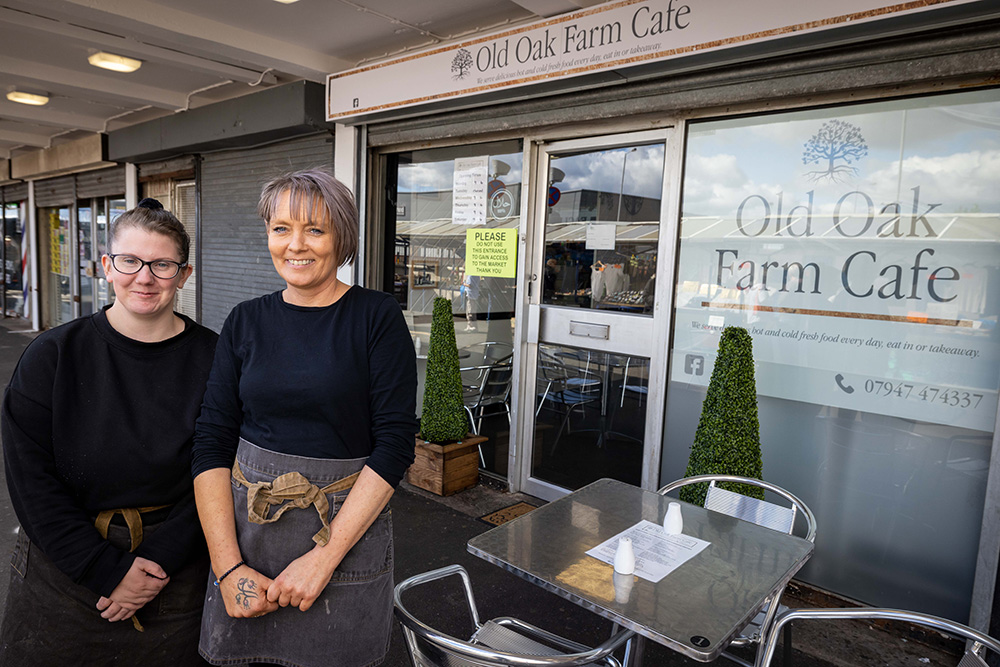 Two people standing in front of the Old Oak Farm Cafe