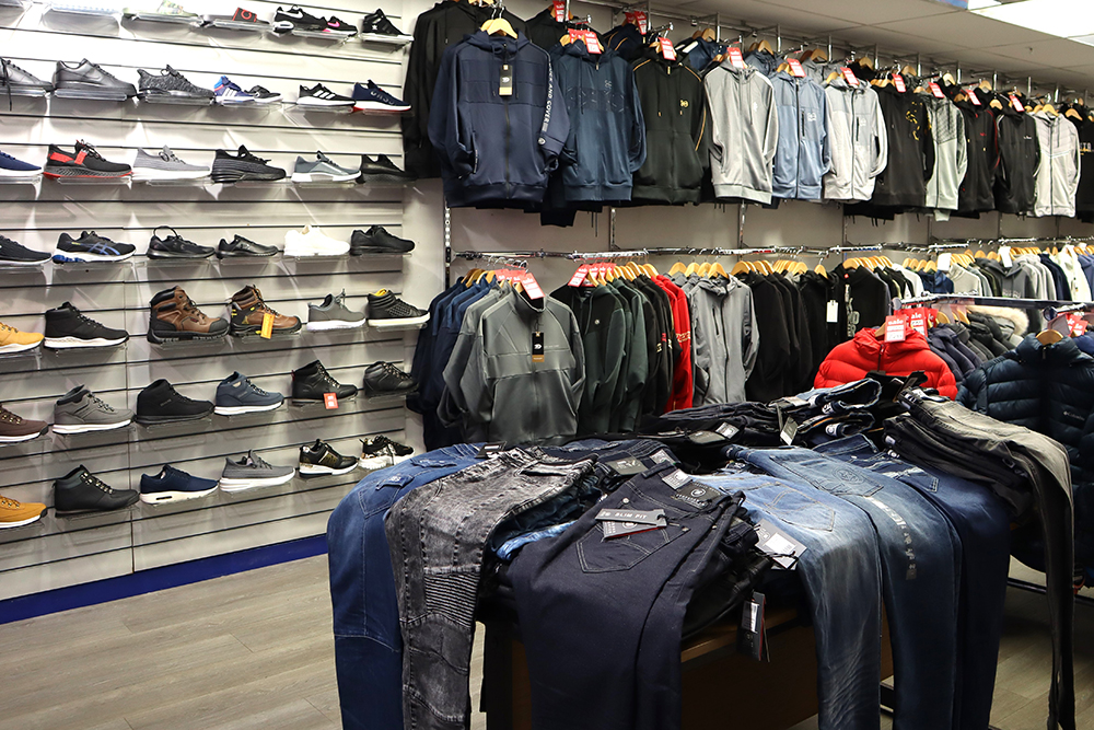 Rows of shoes and rows of clothes on rails